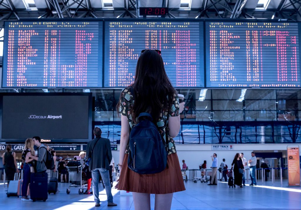 En flicka som tittar på en tidtavla på en flygplats