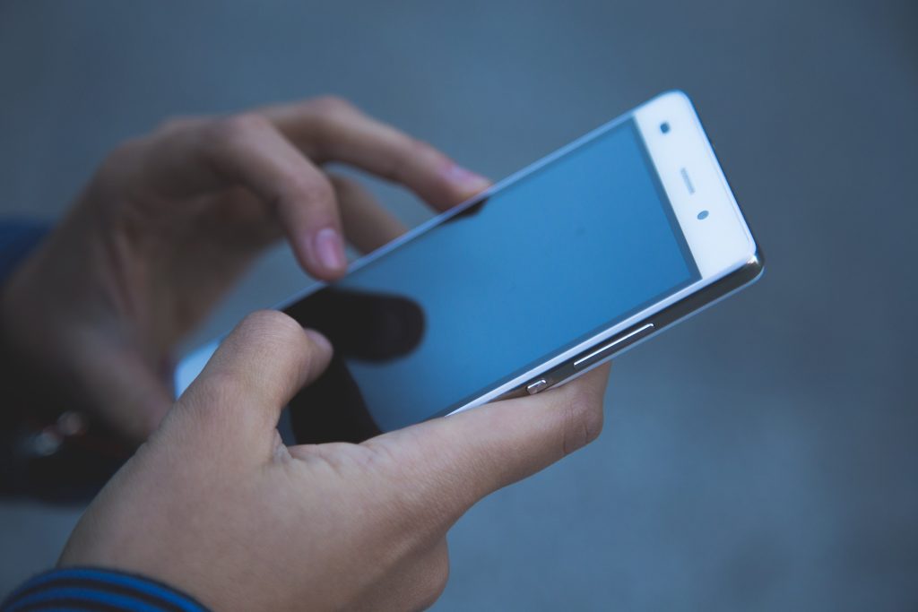 Närbild på någon som håller en mobiltelefon